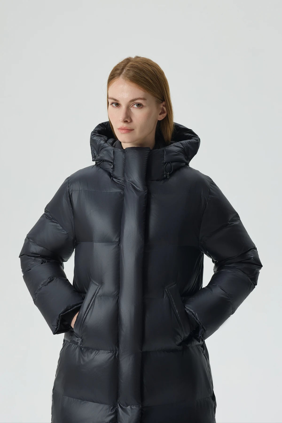 A woman wearing a black Waukee long down puffer.